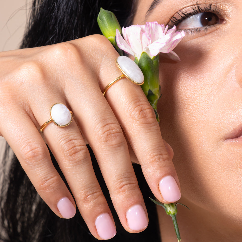 Two rings with different cuts of rainbow gemstones on elegant gold vermeil settings.